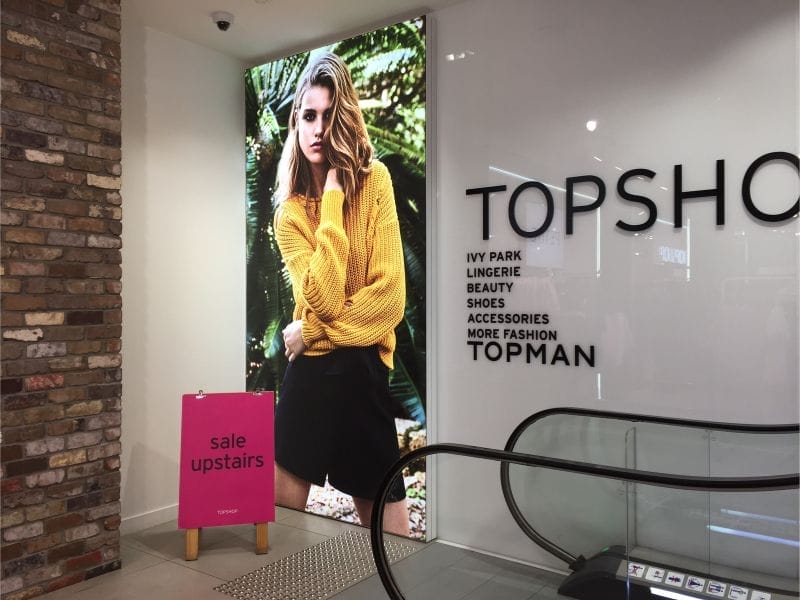 wall-mounted-brandframe-02-illuminated-portrait-orientation-of-wall-mounted-Brandframe-at-fashion-store-escalators.jpg